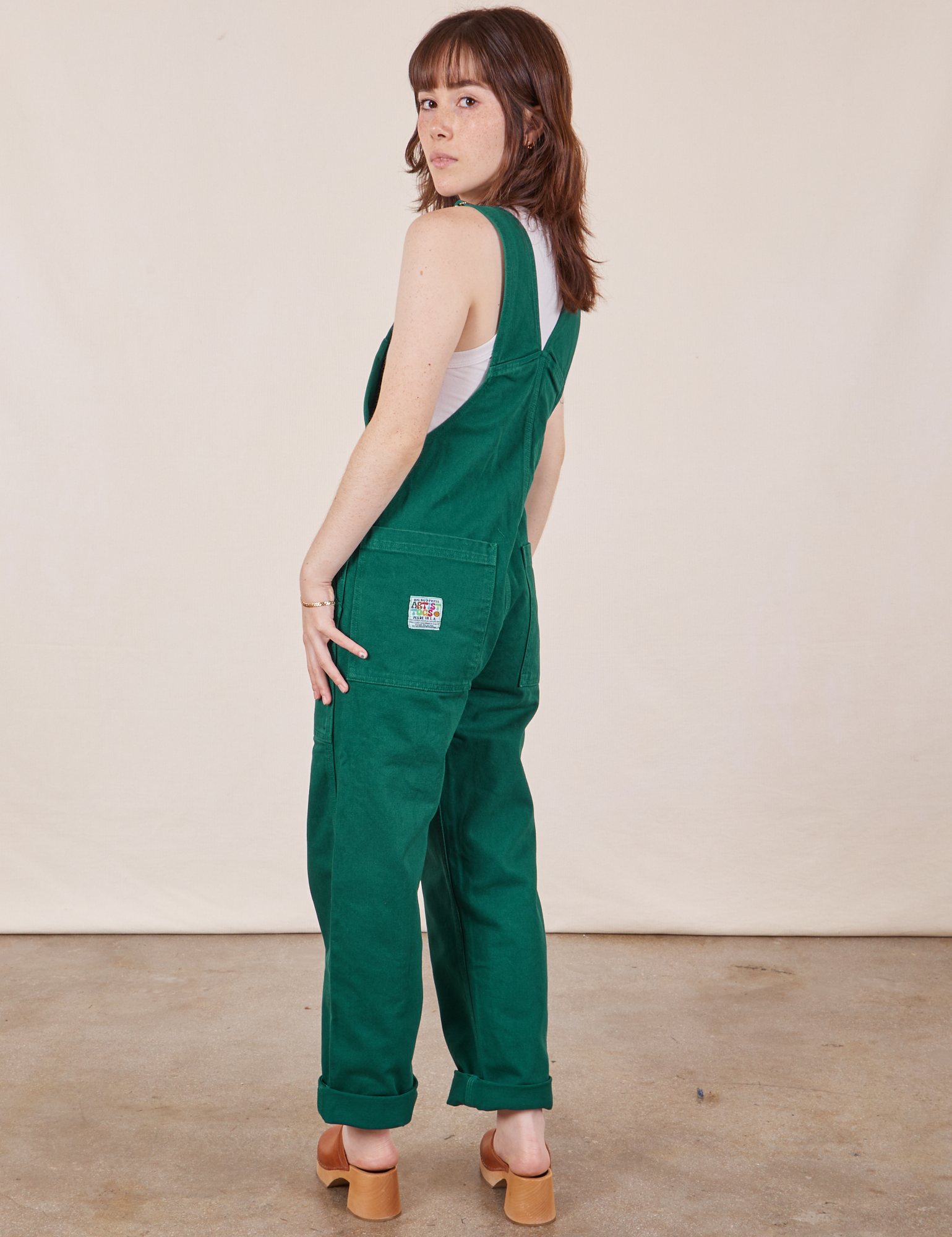 Angled back view of Original Overalls in Mono Hunter Green worn by Hana