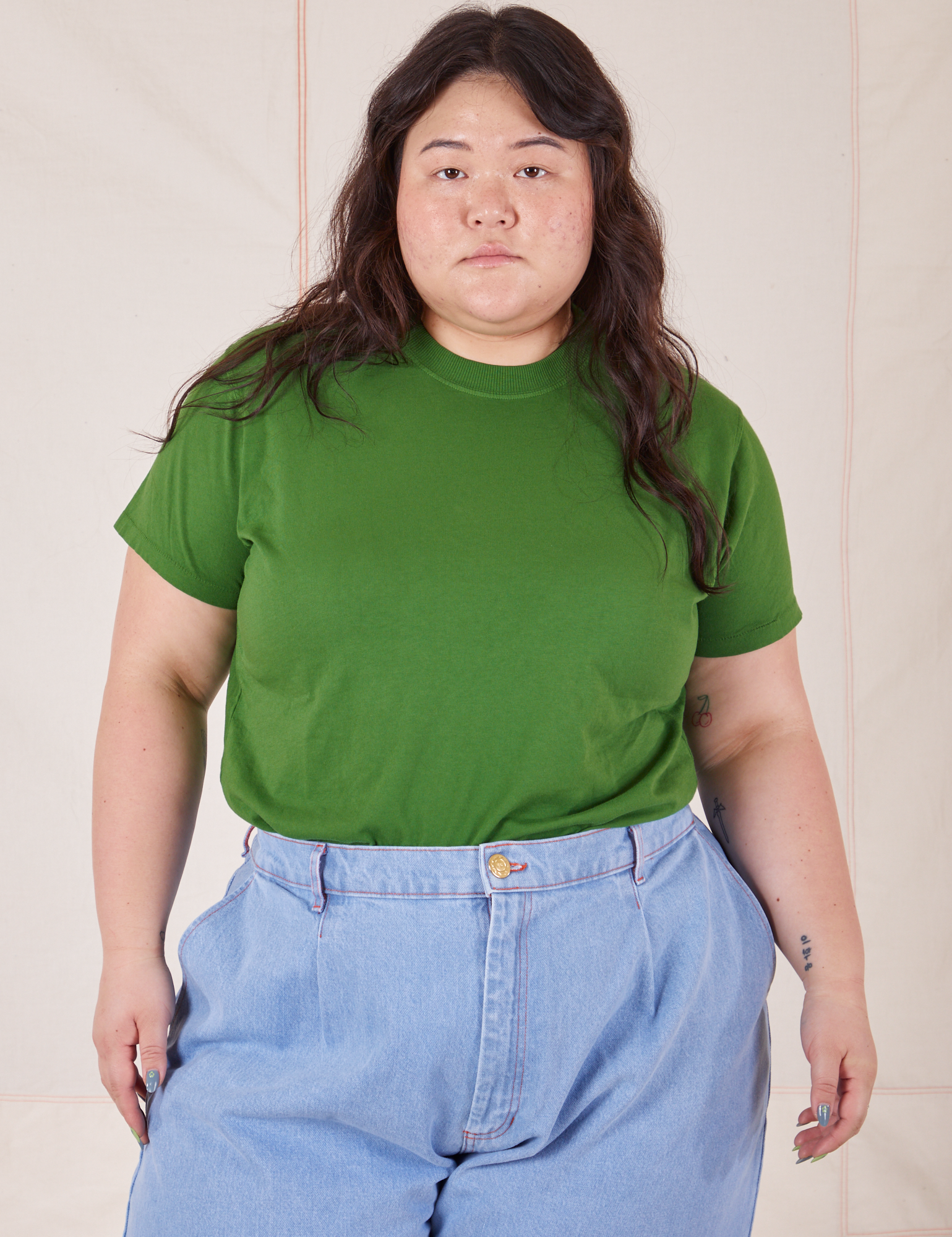 Ashley is wearing Organic Vintage Tee in Lawn Green tucked into light wash Trouser Jeans