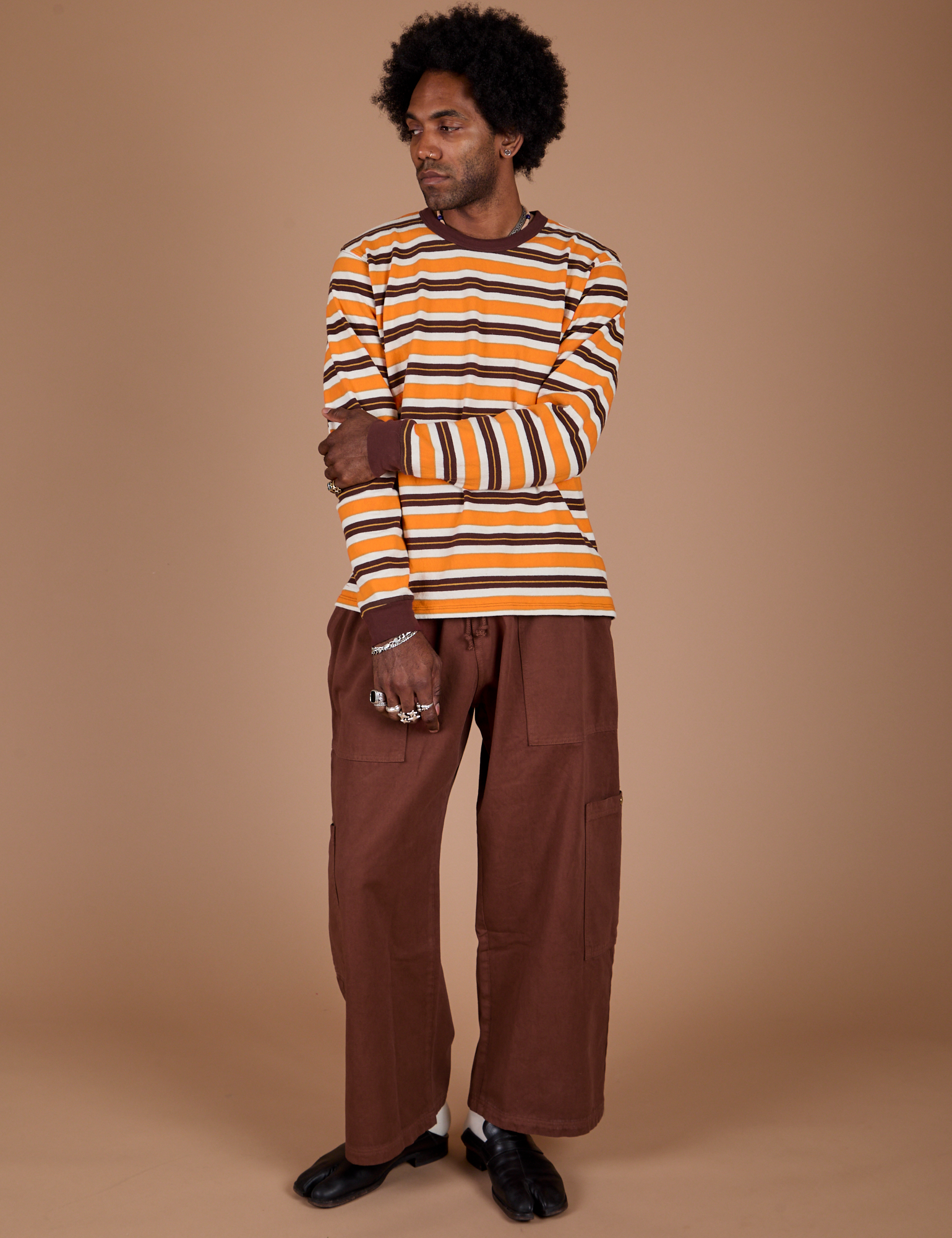 Jerrod is wearing Long Sleeve Striped Burly Tee in Orange and Drop Pocket Cargo Pants in Fudgesicle Brown