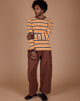 Jerrod is wearing Long Sleeve Striped Burly Tee in Orange and Drop Pocket Cargo Pants in Fudgesicle Brown