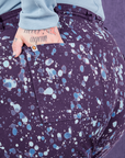 Marble Splatter Work Pants in Nebula Purple back pocket close up. Sam has their hand in the pocket.