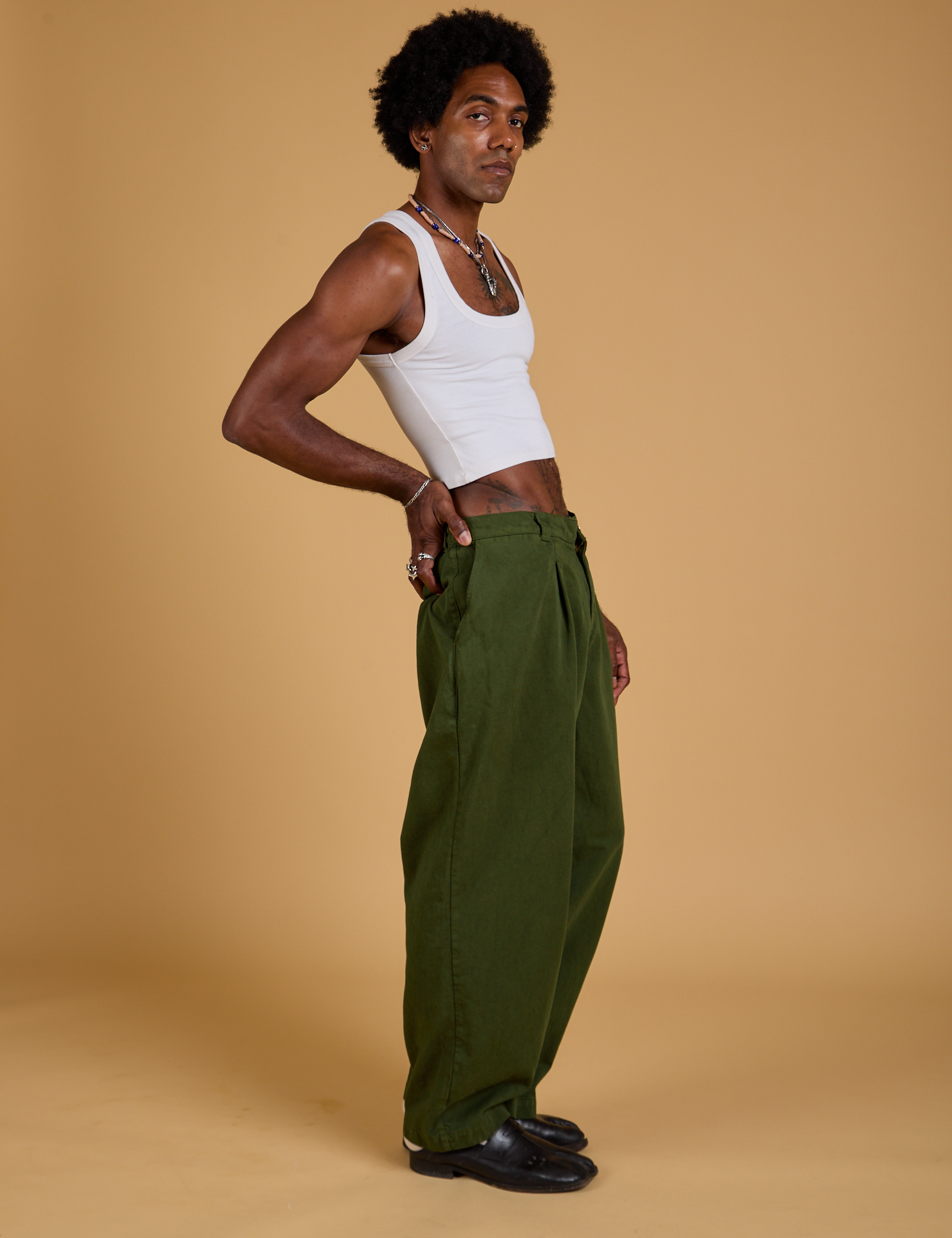 Side view of Baggy Mid-Rise Trousers in Evergreen and vintage tee white Cropped Tank on Jerrod