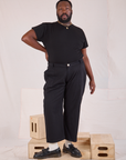 Elijah is 6'3" and wearing 1XL Mid-Rise Work Pants in Basic Black and black Organic Vintage Tee