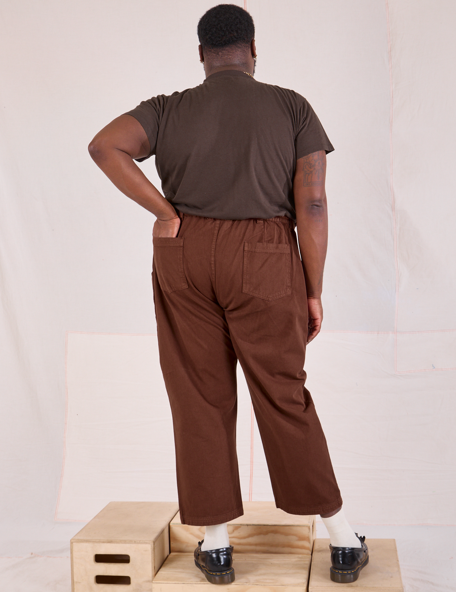 Back view of Mid-Rise Work Pants in Fudgesicle Brown and espresso brown Organic Vintage Tee on Elijah