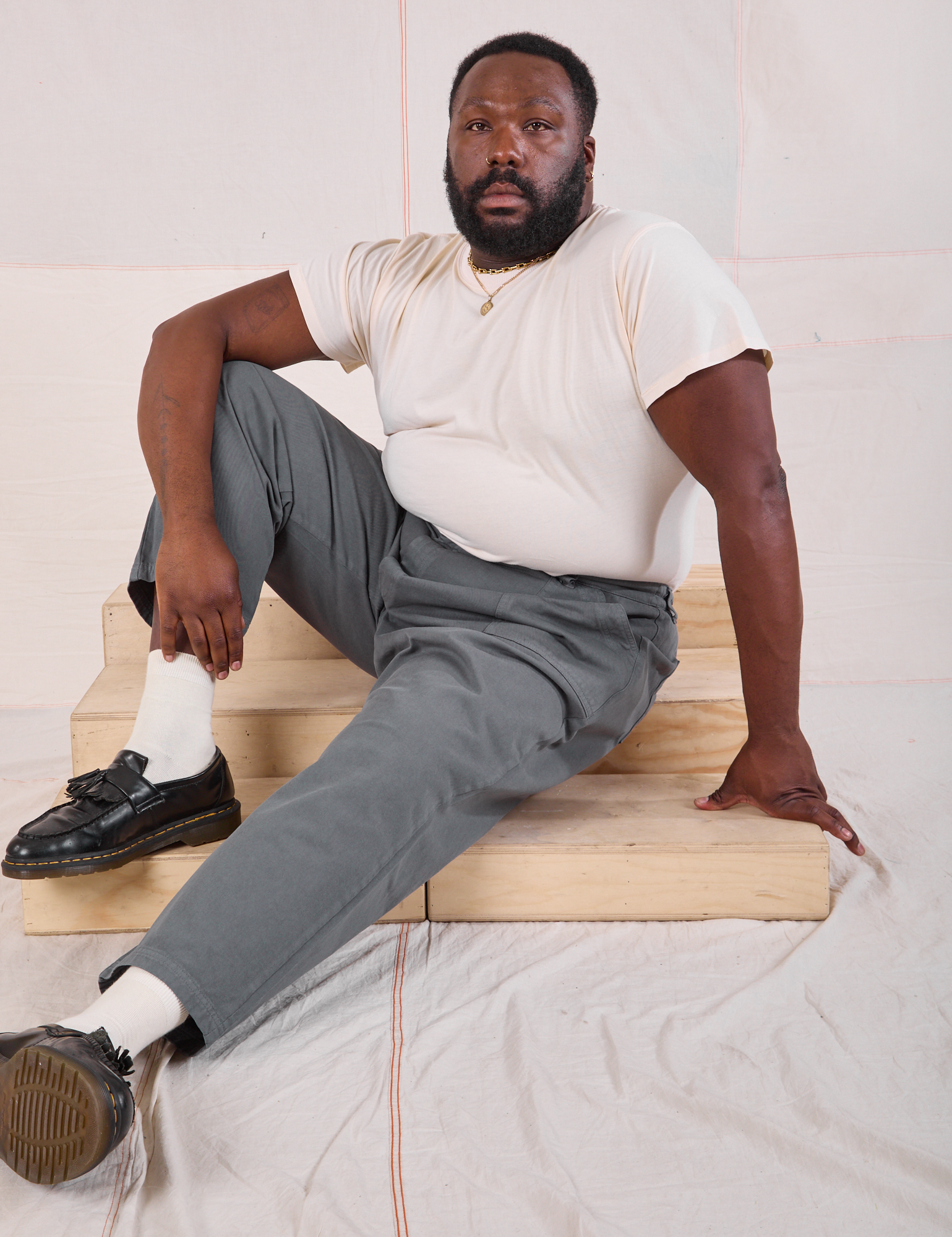 Elijah is wearing Mid-Rise Work Pants in Slate Grey and Organic Vintage Tee in vintage tee off-white