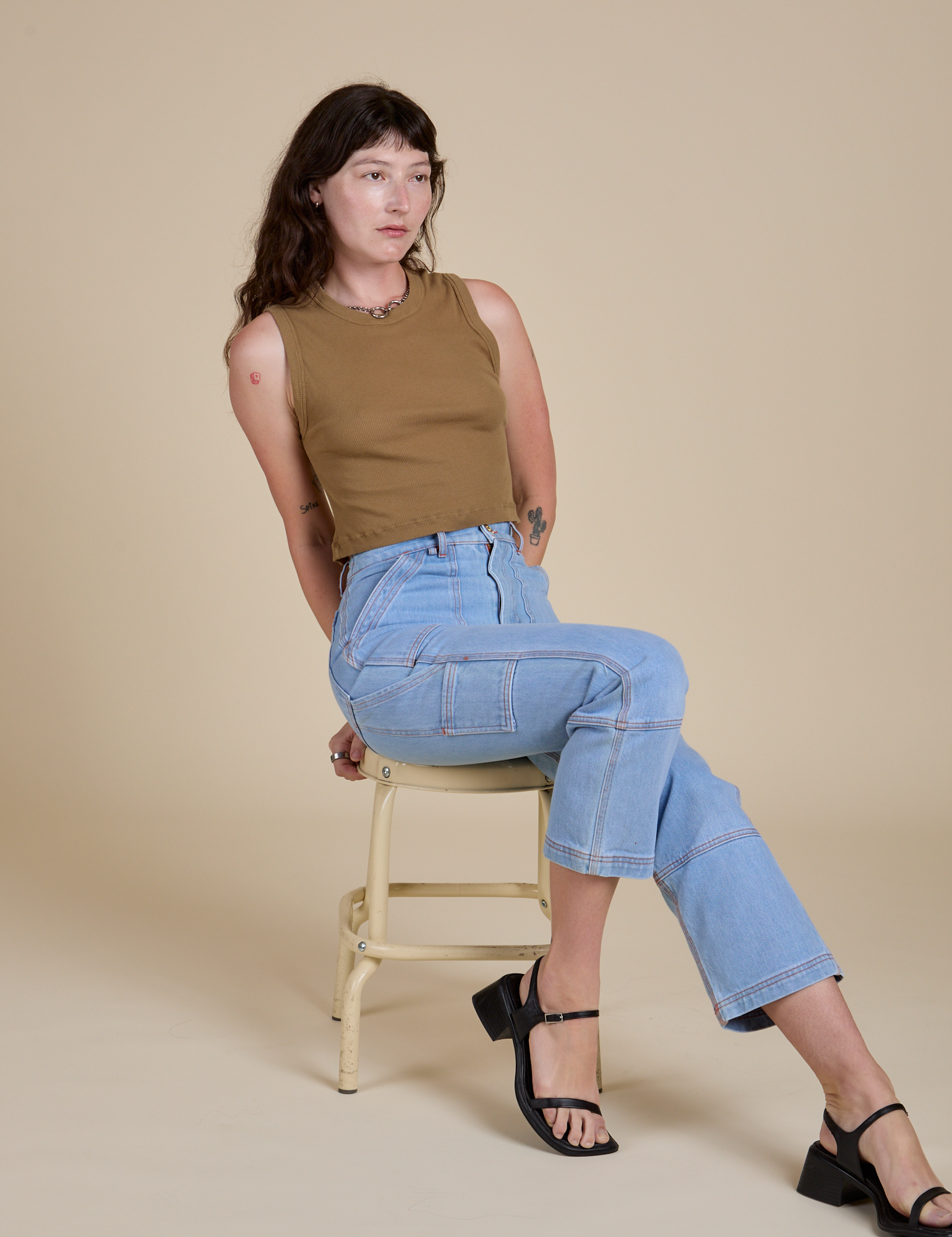 Alex is wearing Muscle Tee in Desert Brown and light wash Carpenter Jeans