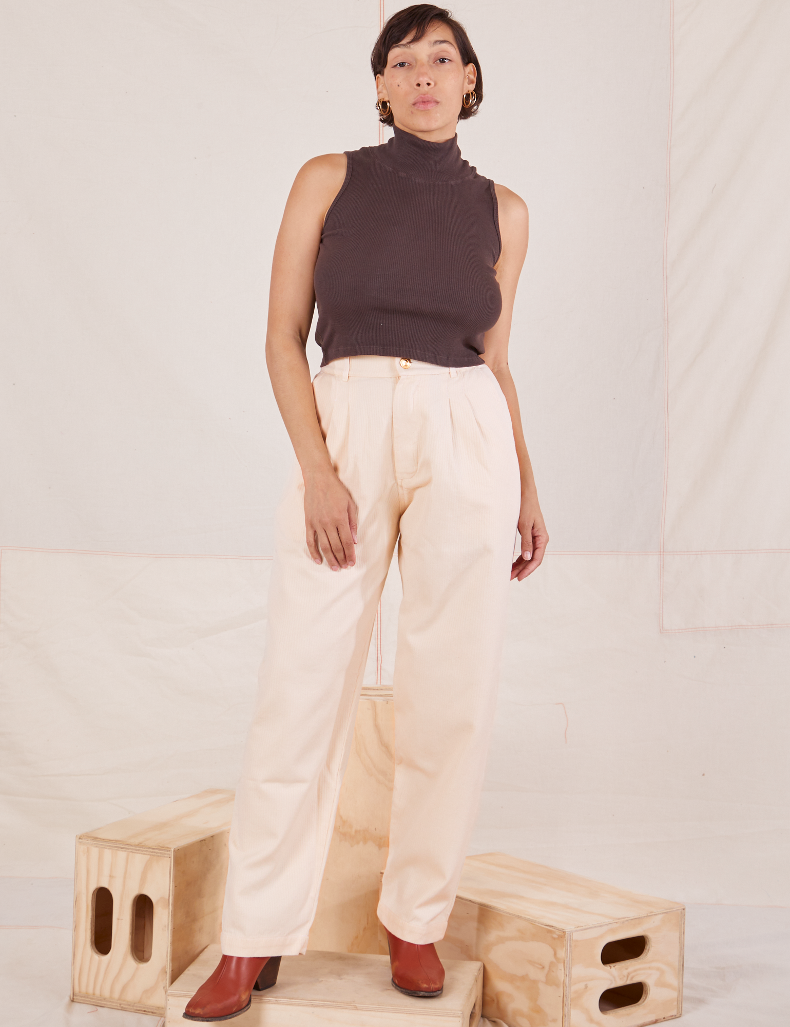 Tiara is 5&#39;4&quot; and wearing S Heritage Trousers in Vintage Off-White paired with the Sleeveless Turtleneck in espresso brown