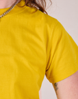 Organic Vintage Tee in Golden Yellow sleeve close up on Alex