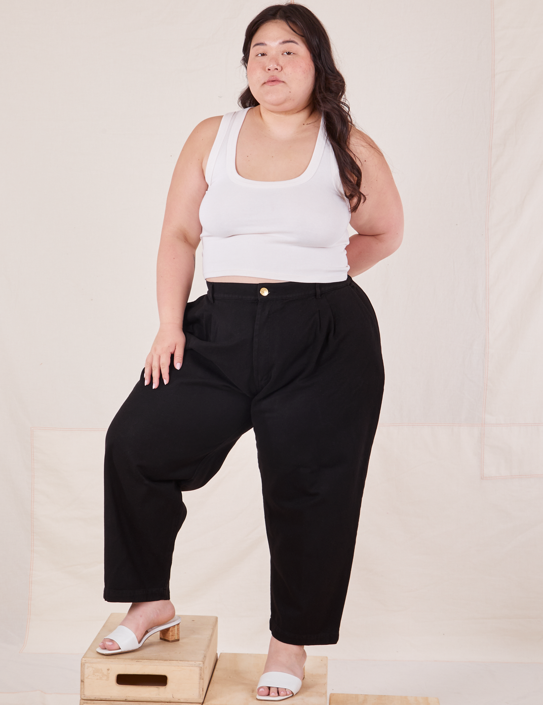 Ashley is 5'7" and wearing 1XL Petite Organic Trousers in Basic Black paired with vintage off-white Cropped Tank Top
