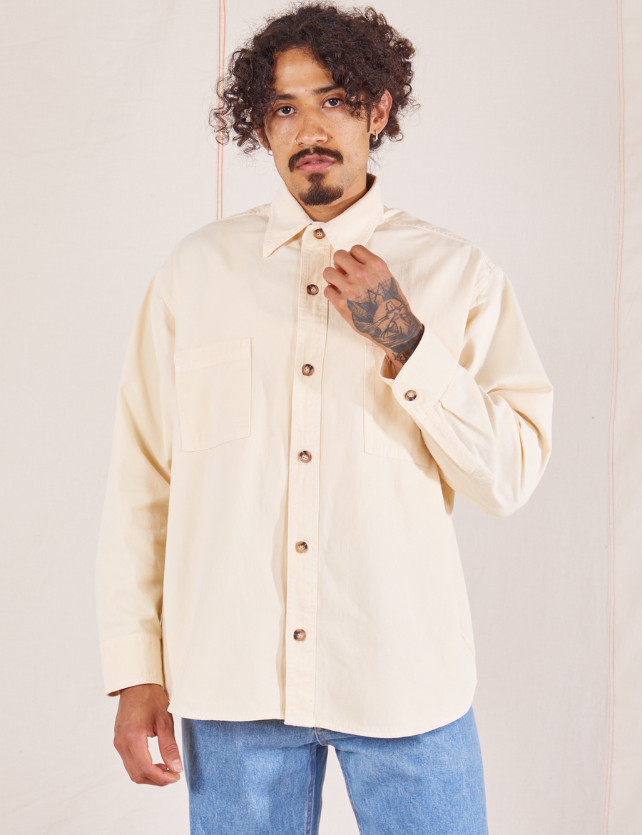 Jesse is wearing a buttoned up Oversize Overshirt in Vintage Off-White