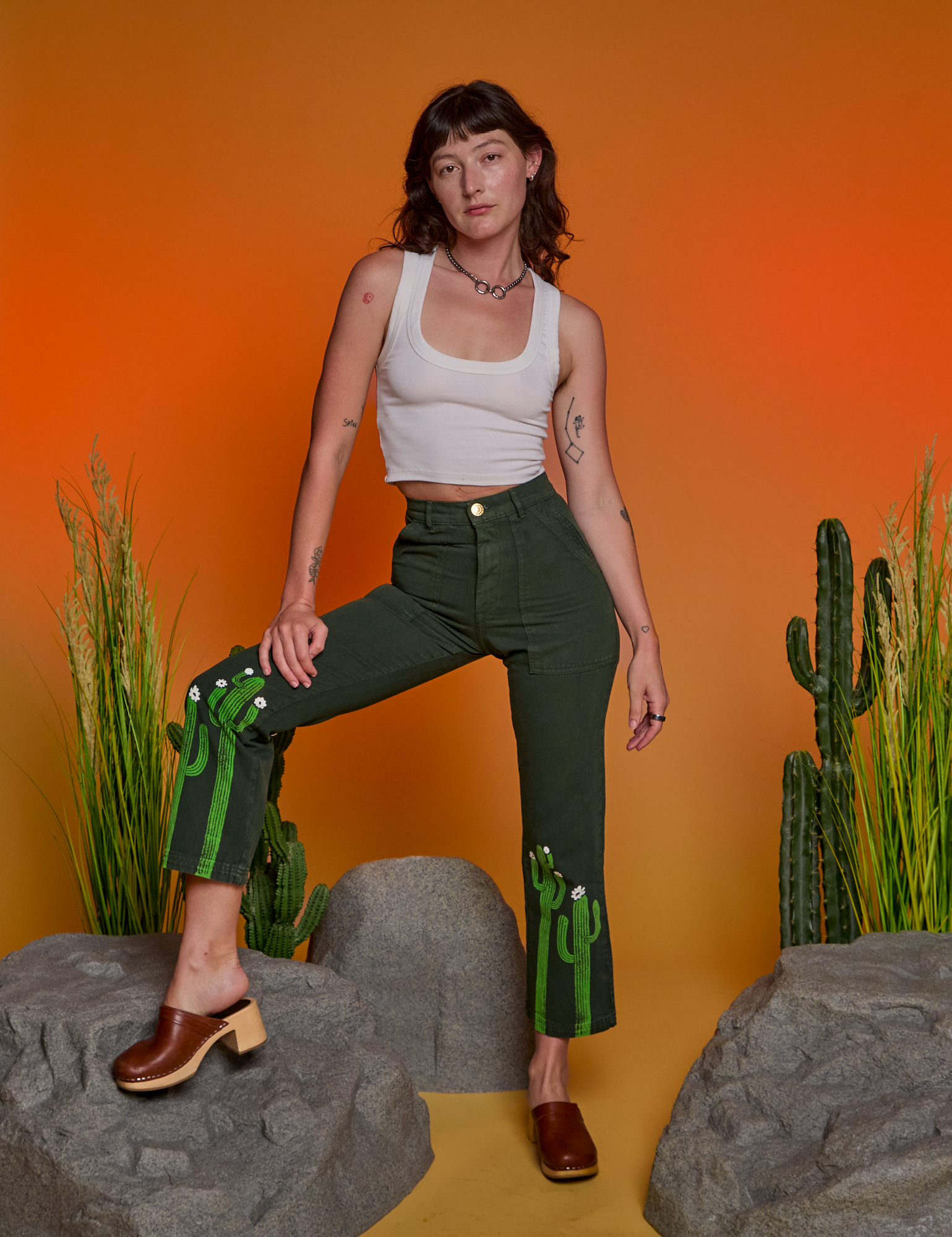 Alex is wearing Paintstamped Work Pants in Cactus and Cropped Tank in Vintage Tee White