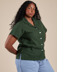 Angled front view of Pantry Button-Up in Swamp Green on Meghna
