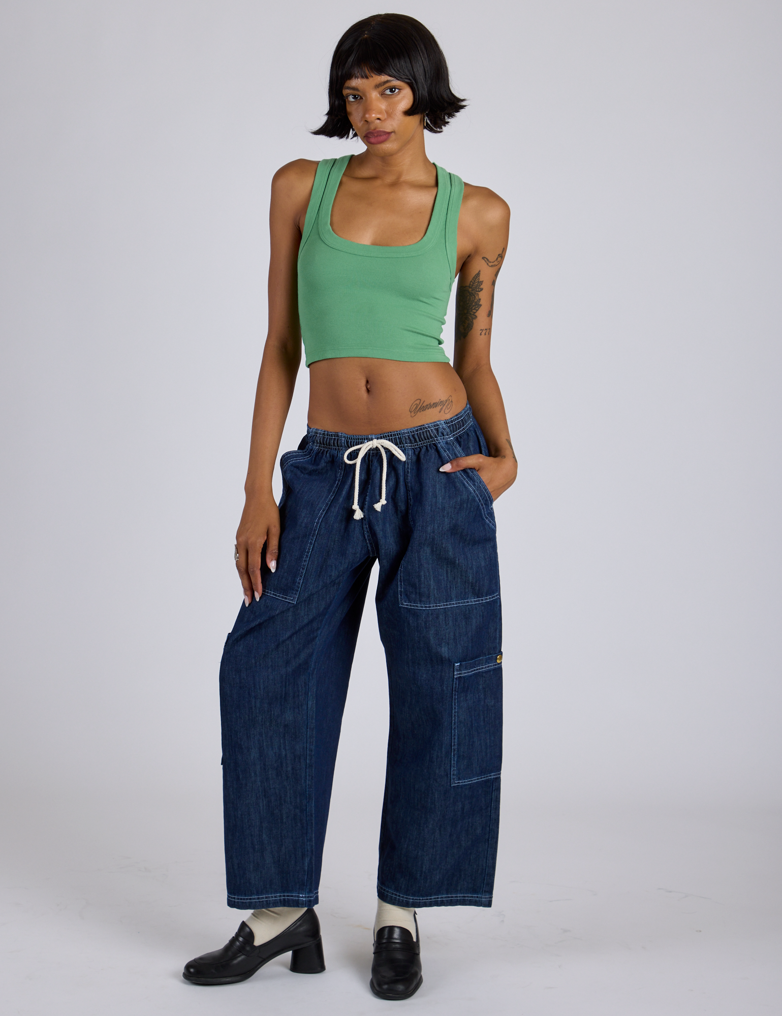 Kira is wearing Tank Top in Seafoam Green and dark wash Denim Drop Pocket Pants