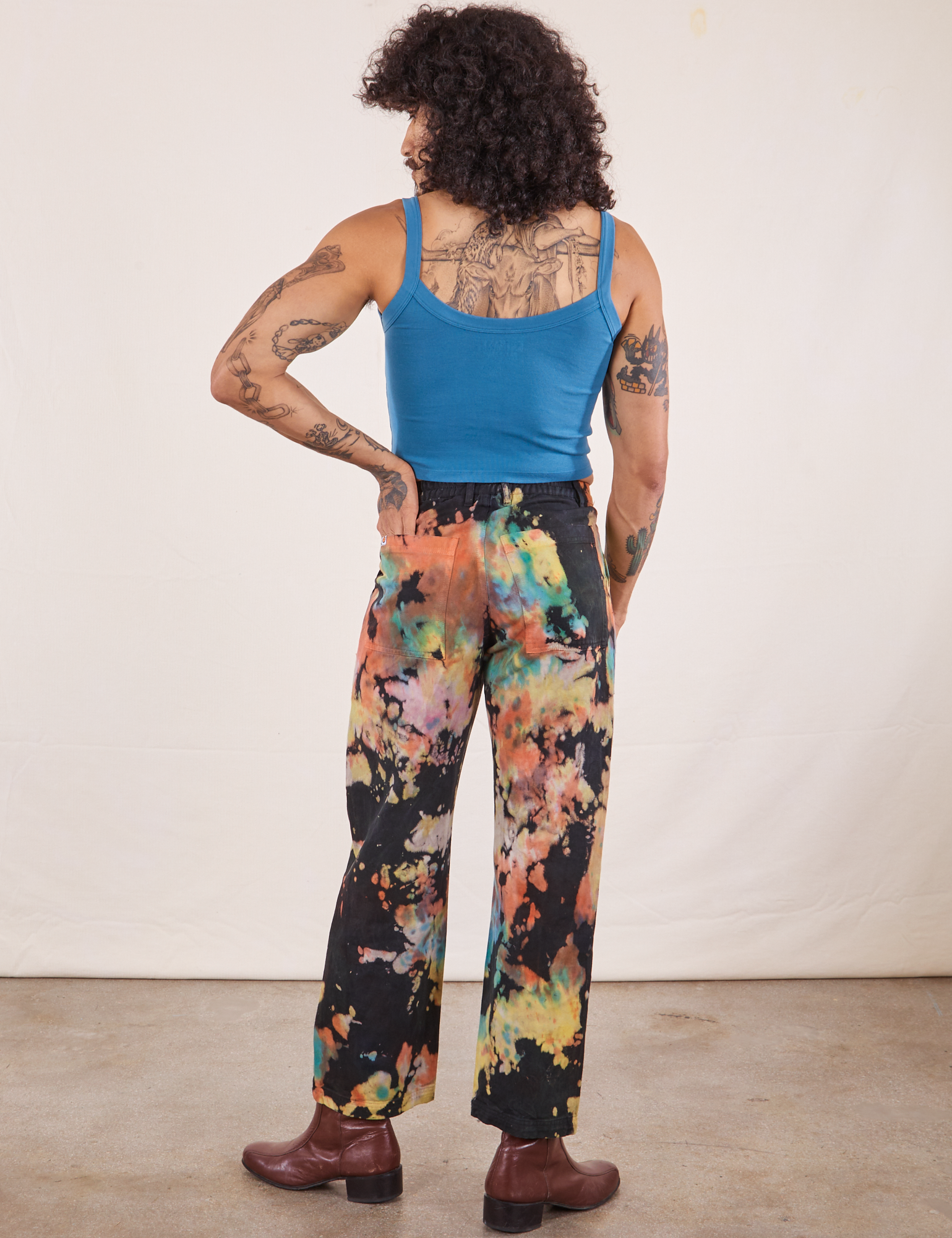 Back view of Rainbow Magic Waters Work Pants and marine blue Cropped Tank worn by Jesse