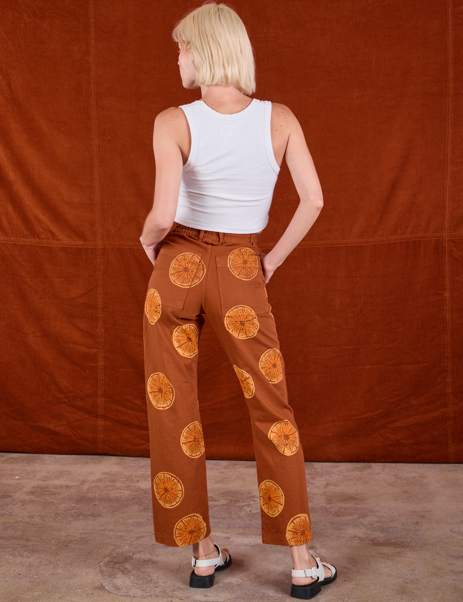 Back view of Paintstamped Work Pants in Orange and Cropped Tank in Vintage Tee Off-White on Madeline