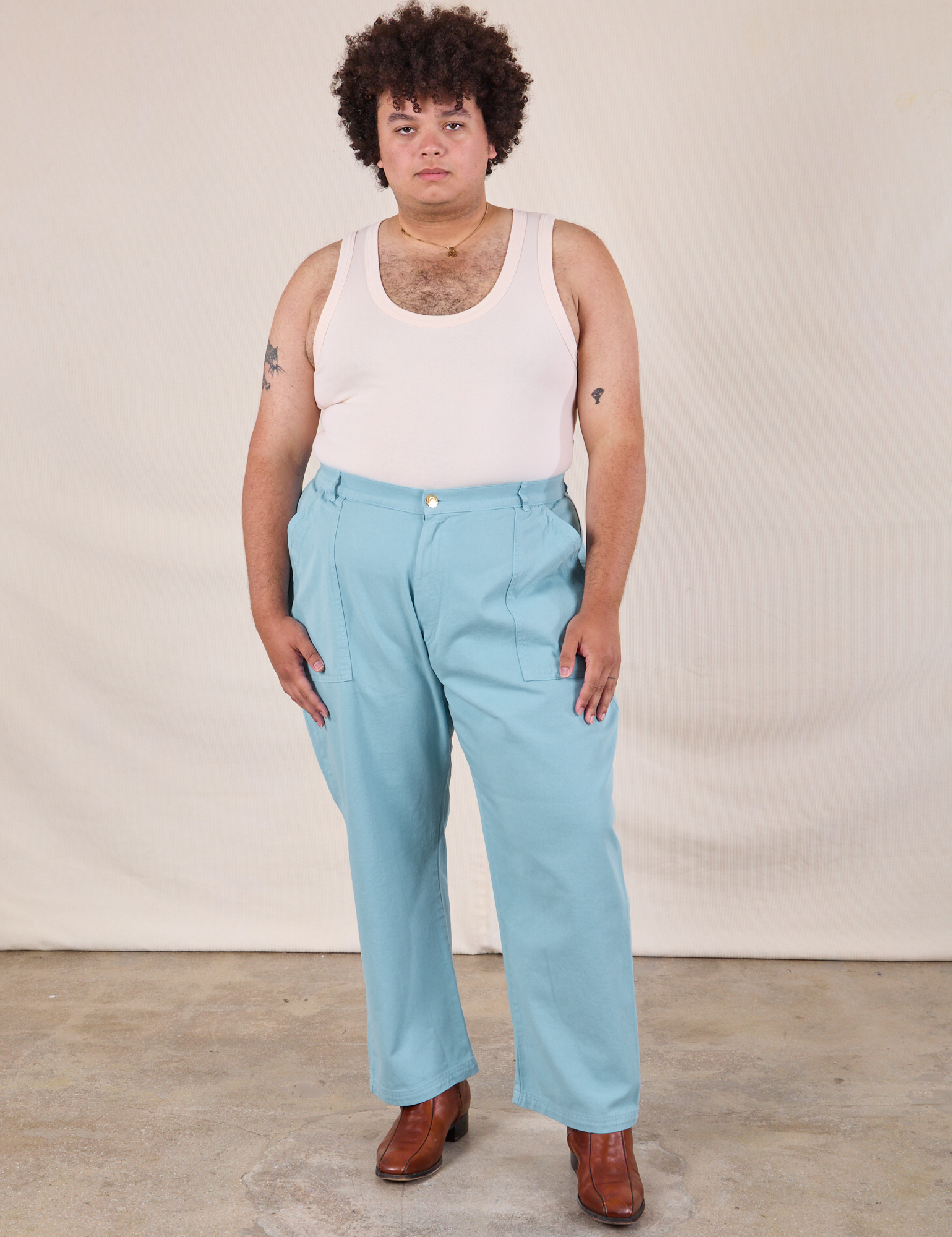Miguel is 6&#39;0&quot; and wearing 2XL Work Pants in Baby Blue paired with a Tank Top in vintage tee off-white