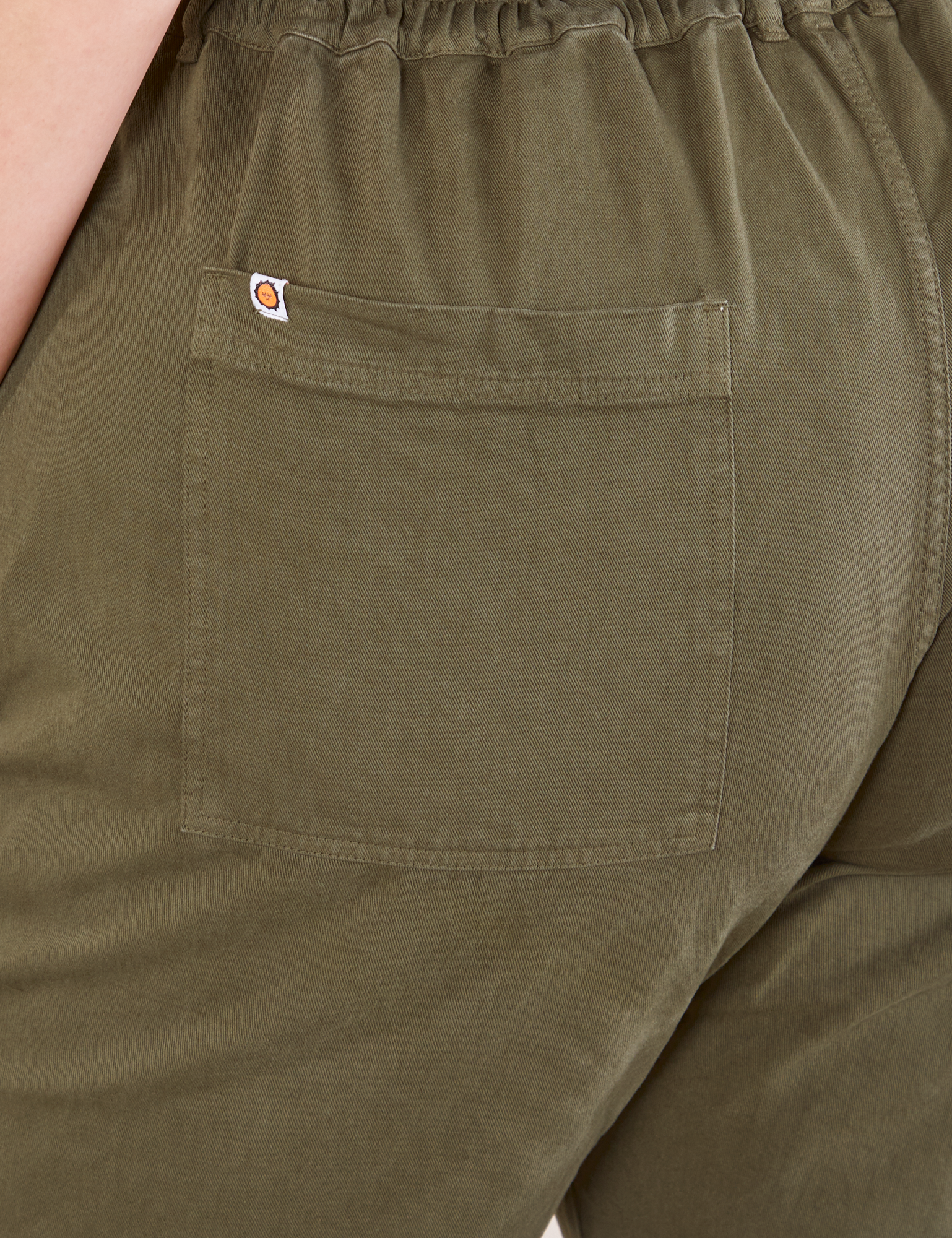 Short Sleeve Jumpsuit in Surplus Green back pocket close up on Bree