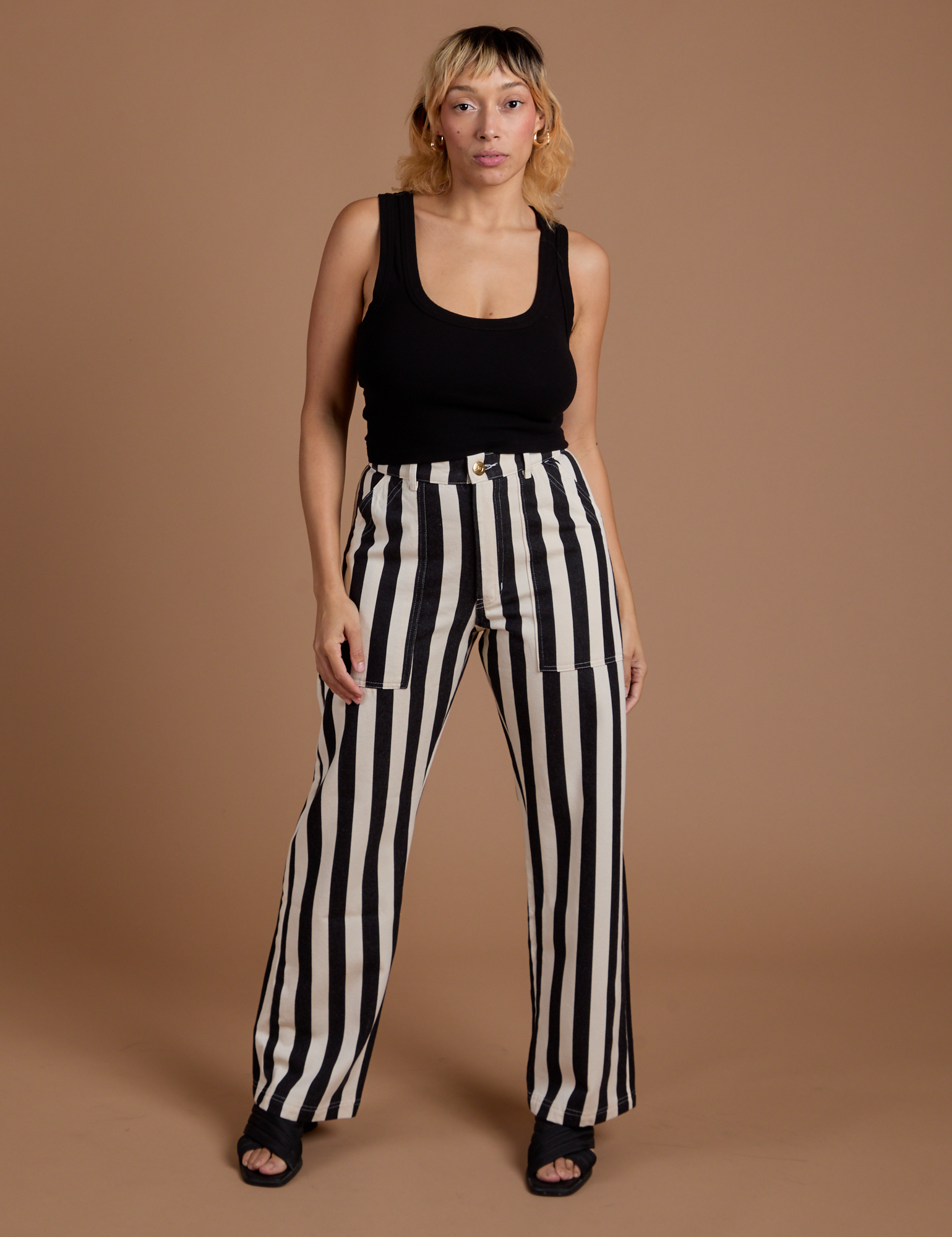 Tiara is 5’4” and wearing S Black Stripe Work Pants in White paired with black Cropped Tank