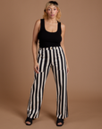 Tiara is 5’4” and wearing S Black Stripe Work Pants in White paired with black Cropped Tank
