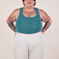 Sam is wearing size XL Tank Top in Marine Blue paired with vintage off-white Western Pants
