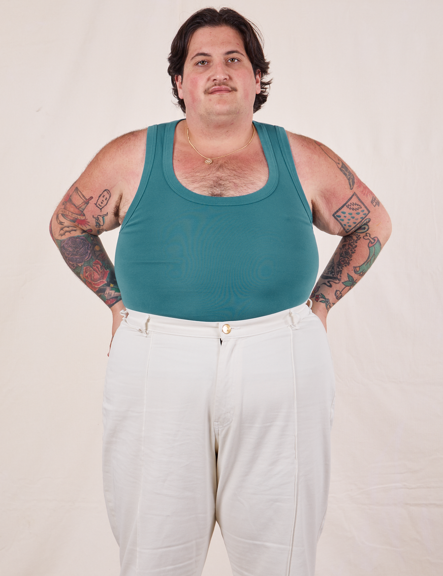 Sam is wearing size XL Tank Top in Marine Blue paired with vintage off-white Western Pants