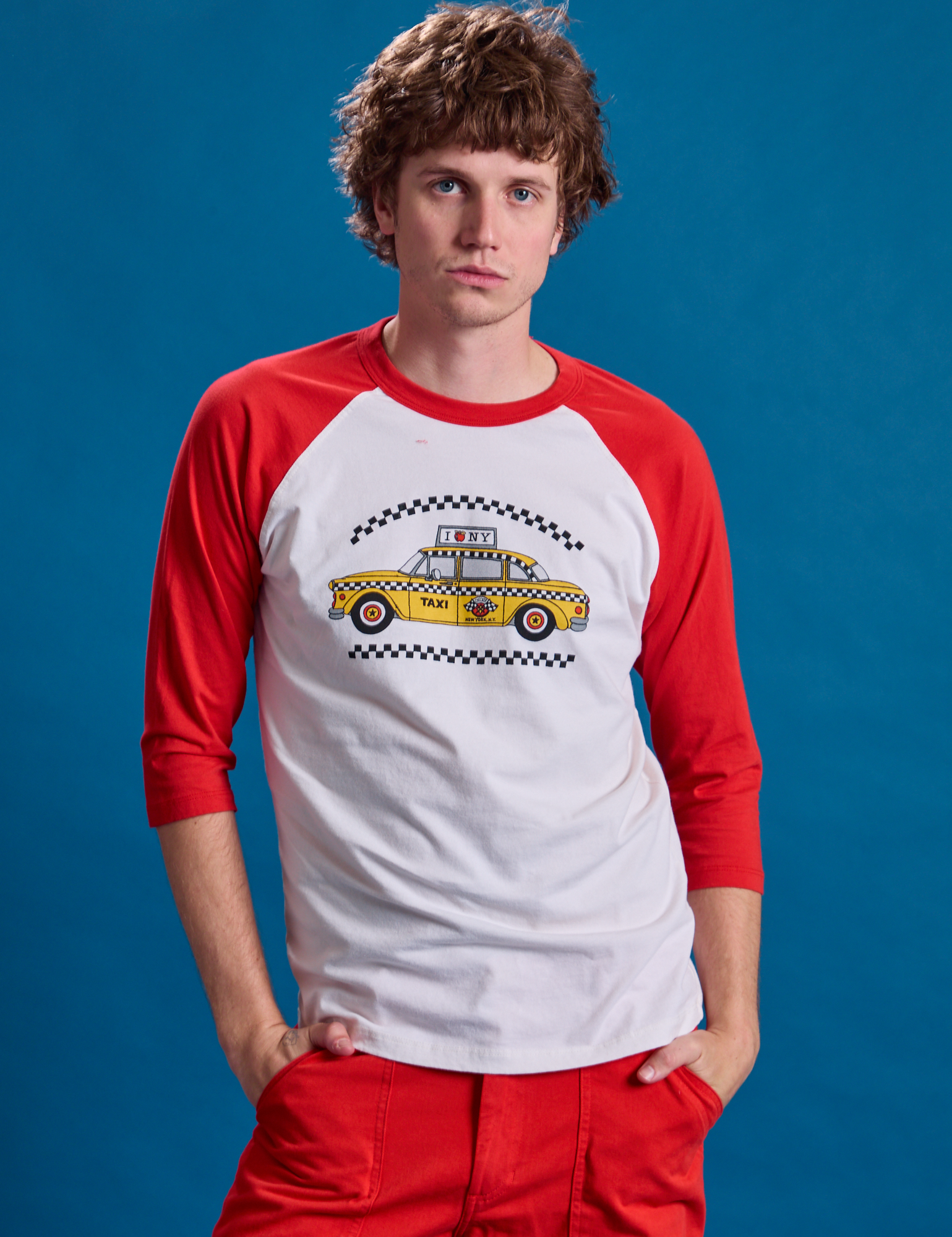 Quinn is 6&#39;3&quot; and wearing M Taxi Raglan Tee in NYC with a yellow taxi graphic