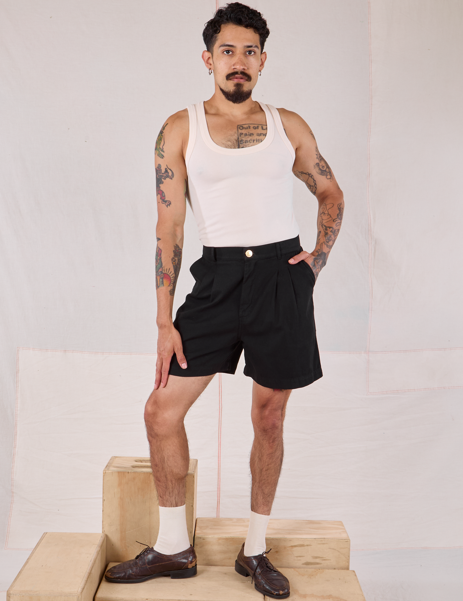 Jesse is 5’8” and wearing XS Trouser Shorts in Basic Black paired with a Tank Top in vintage tee off-white