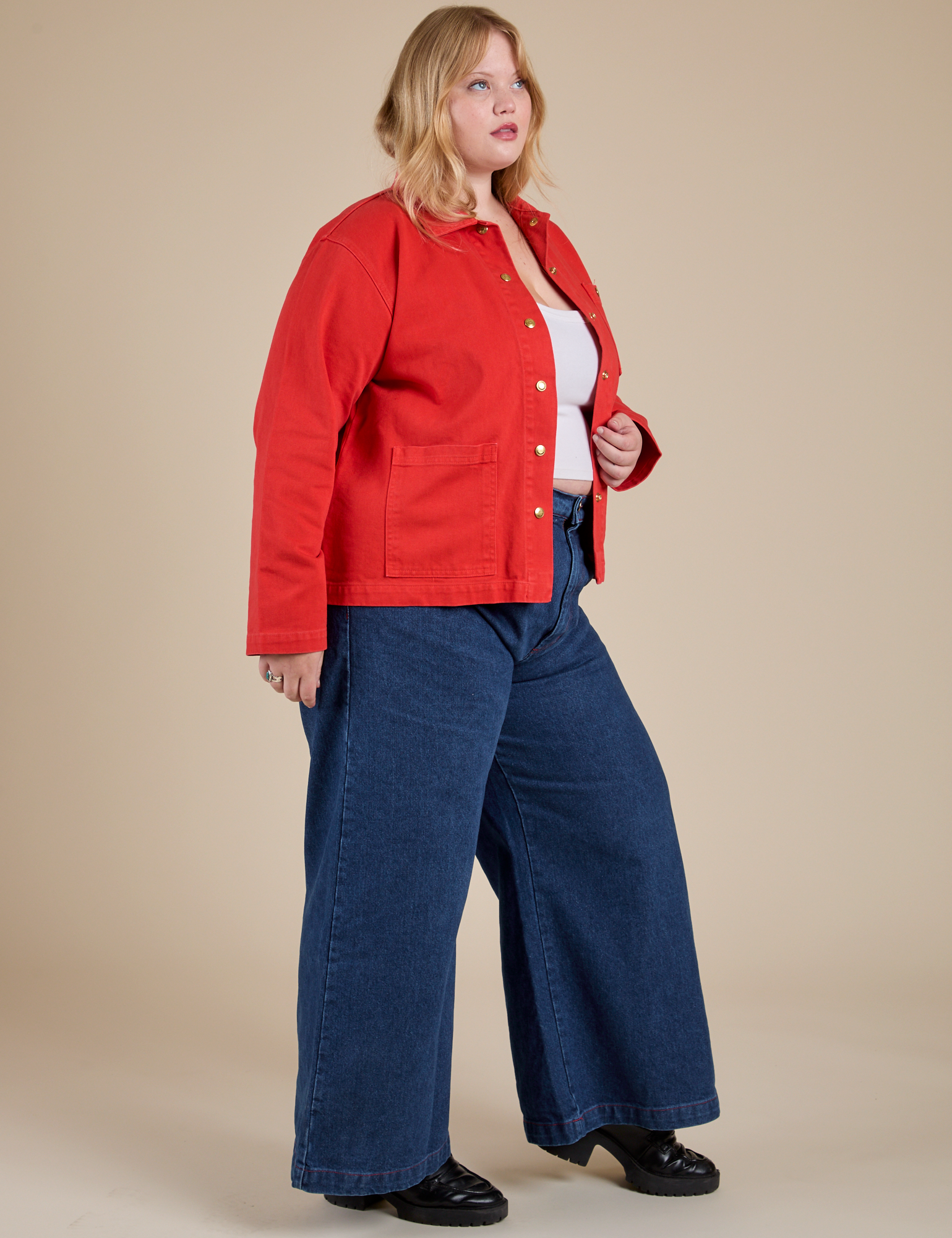 Side view of Denim Work Jacket in Mustang Red and dark wash Indigo Wide Leg Trousers on Juliet