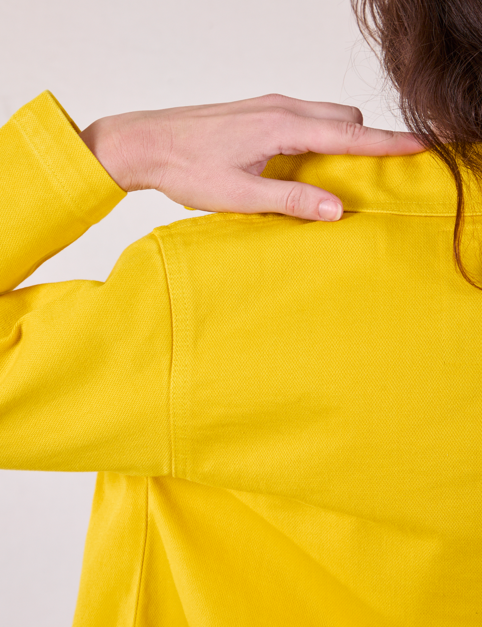 Back shoulder close up of Denim Work Jacket in Golden Yellow on Alex