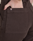 Close up of Alex's hand the back pocket of Work Pants in Espresso Brown