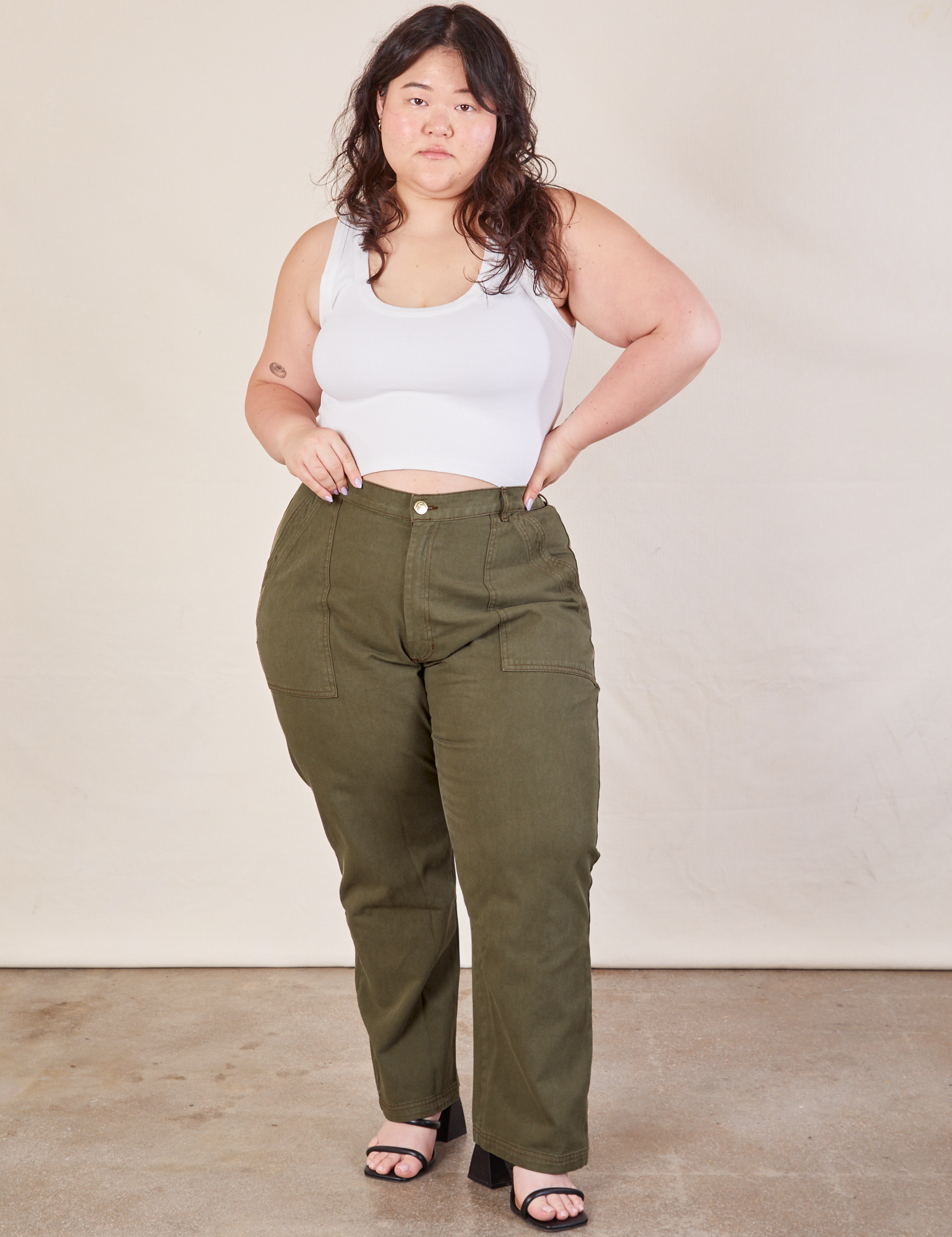 Ashley is 5&#39;7&quot; and wearing 1XL Work Pants in Surplus Green paired with Cropped Tank in vintage tee off-white