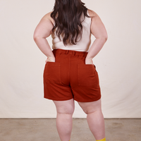 Back view of Classic Work Shorts in Paprika. Ashley has both hands in the pockets.