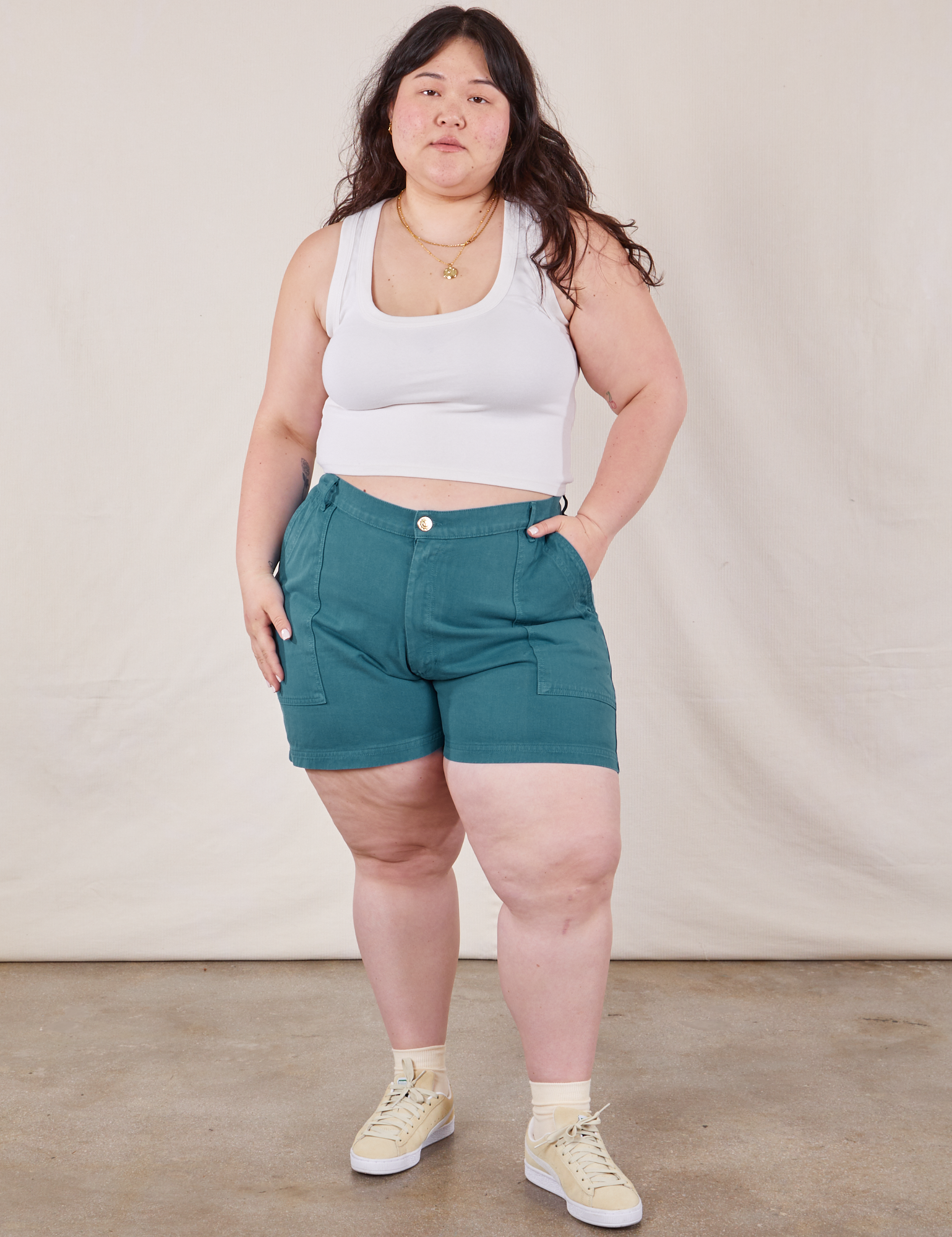 Ashley is 5’7” and wearing 1XL Classic Work Shorts in Marine Blue paired with a Cropped Tank Top in vintage tee off-white