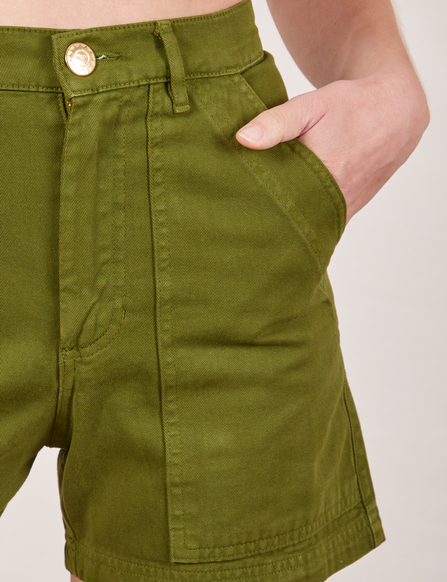 Classic Work Shorts in Summer Olive front pocket close up. Madeline has her hand in the pocket.