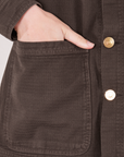 Field Coat in Espresso Brown front pocket close up. Alex has her hand in the pocket.