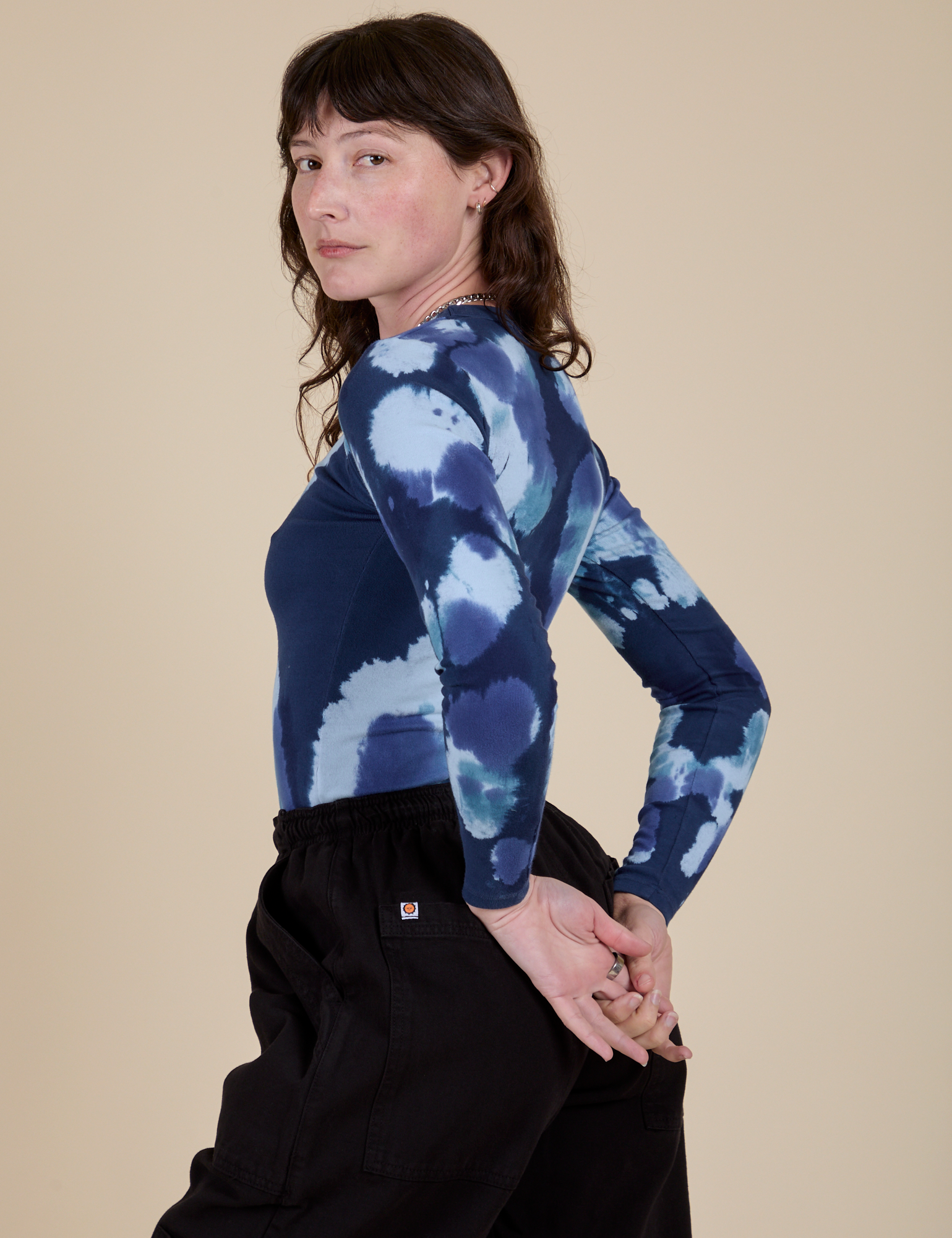 Angled back view of Long Sleeve Baby Tee in Blue Magic Waters on Alex