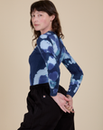 Angled back view of Long Sleeve Baby Tee in Blue Magic Waters on Alex