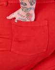 Close up of Sam's hand in the back pocket of Mid-Rise Work Pants in Mustang Red