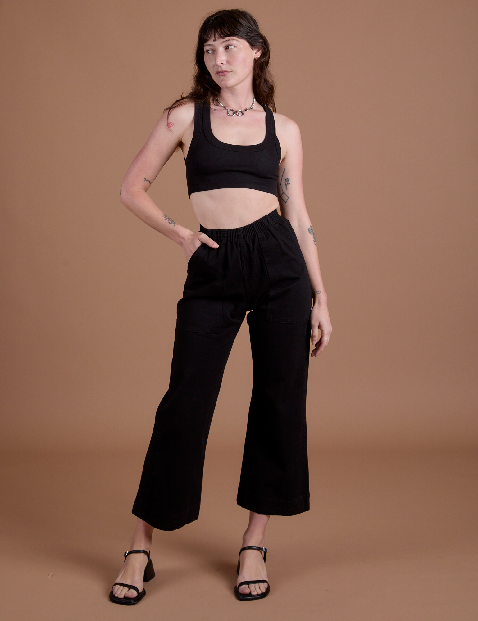 Alex is 5’8” and wearing XXS Action Pants in Basic Black paired with black Mini Tank