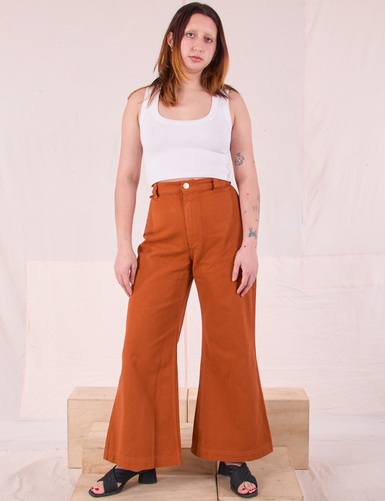 Betty is 5&#39;8&quot; and wearing XS Bell Bottoms in Burnt Terracotta paired with a Cropped Tank in Vintage Tee Off-White