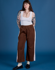 Sydney is 5’9” and wearing M Painted Action Pants in Fudgesicle Brown paired with vintage tee white Cropped Tank