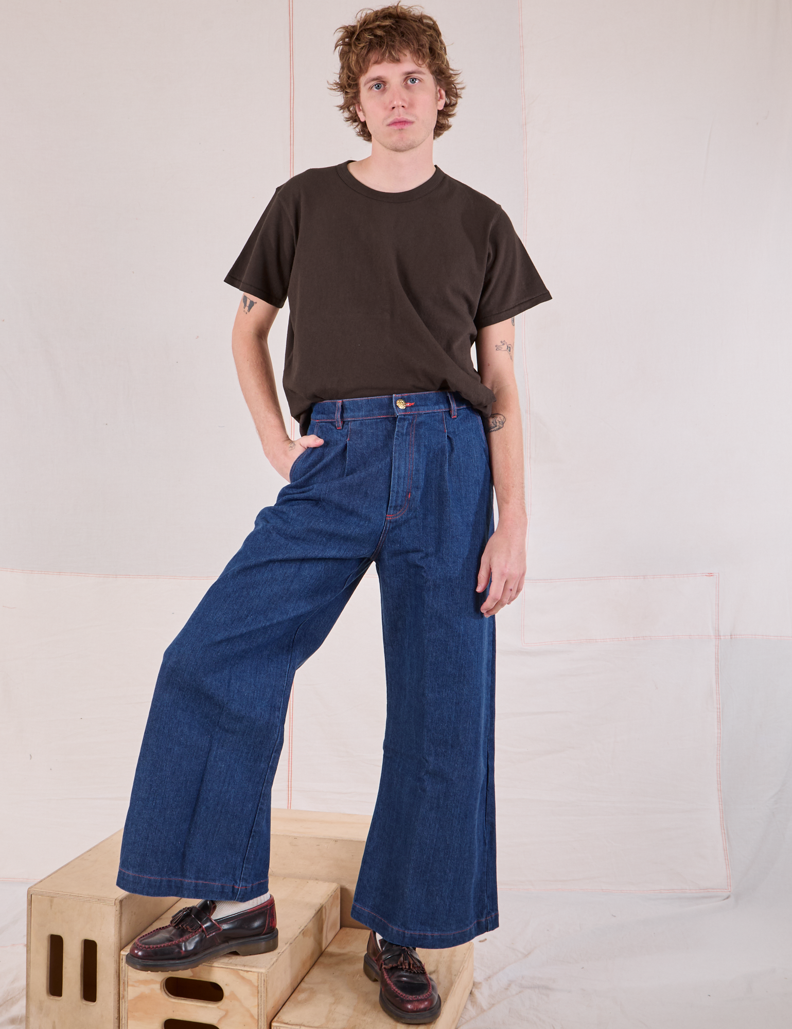 Quinn is wearing Burly Tee in Espresso Brown tucked into dark wash Denim Wide Leg Trousers