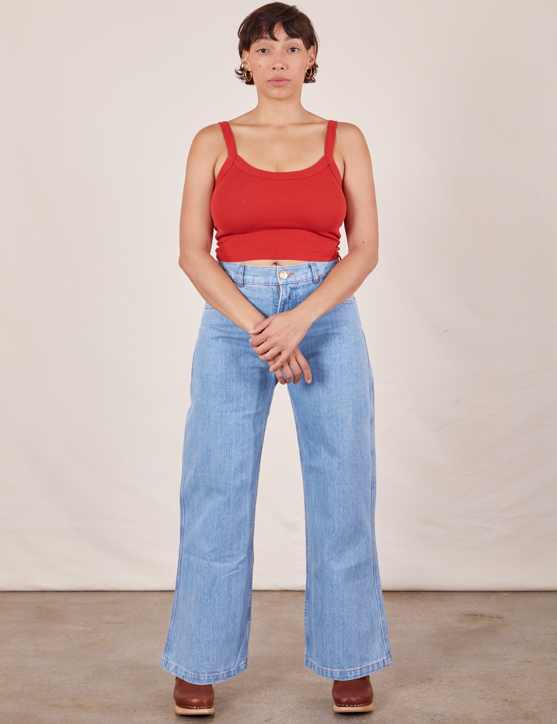 Tiara is wearing Cropped Cami in Mustang Red and light wash Sailor Jeans