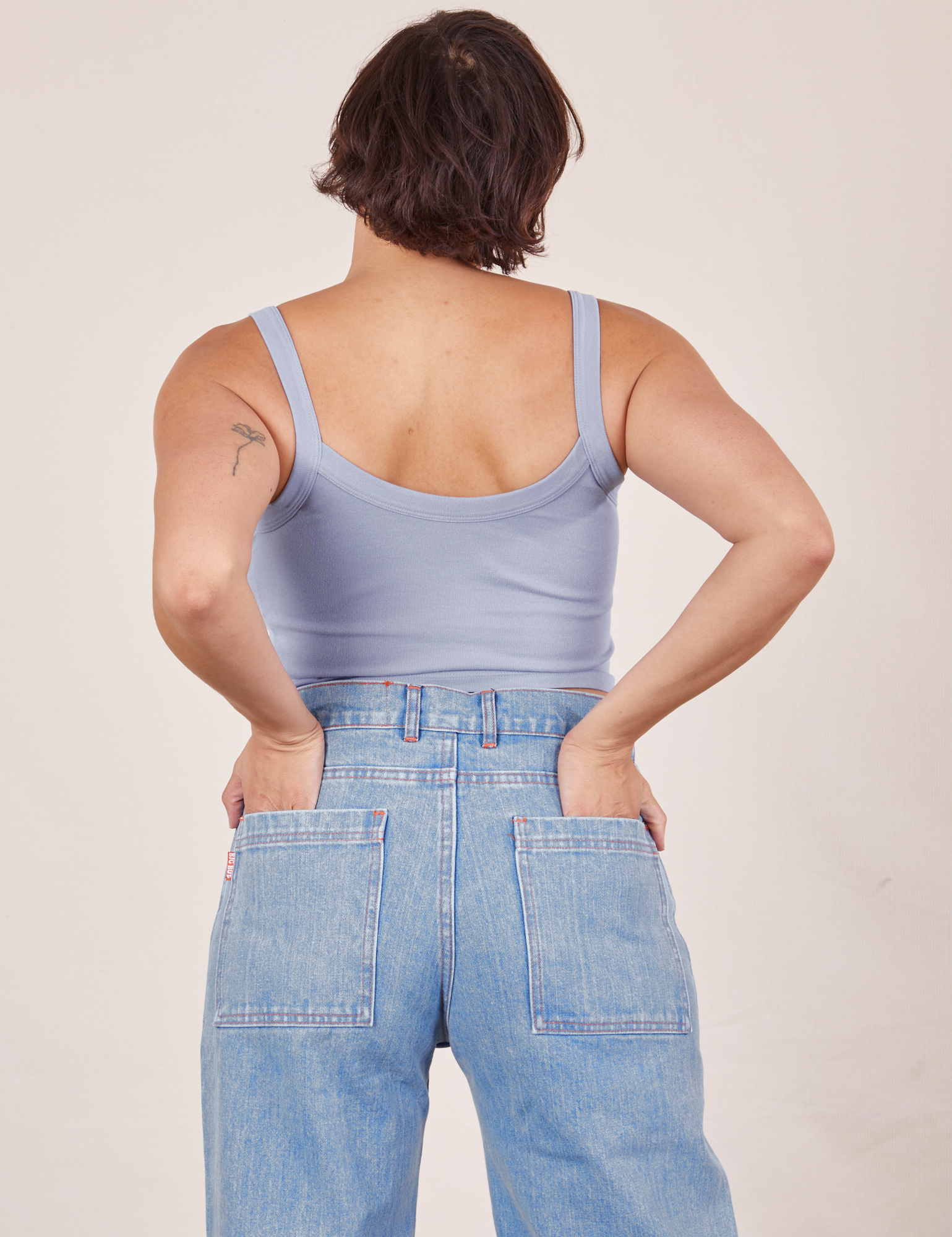 Back view of Cropped Cami in Periwinkle and light wash Sailor Jeans worn by Tiara. She has both hands in the back pant pockets.