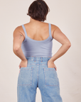 Back view of Cropped Cami in Periwinkle and light wash Sailor Jeans worn by Tiara. She has both hands in the back pant pockets.