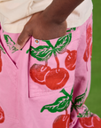 Close up of Isaac's hand in the back pocket of Cherry Paintstamped Work Pants in Bubblegum Pink