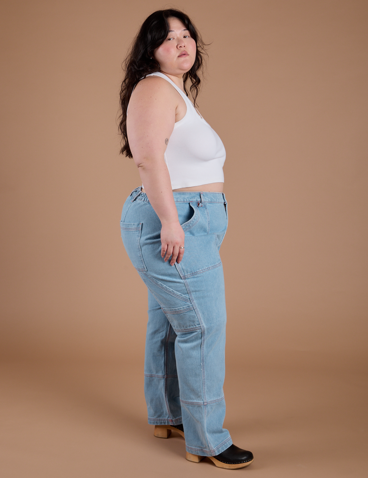 Side view of Carpenter Jeans in Light Wash and Cropped Tank in Vintage Tee White on Ashley