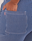 Carpenter Jeans in Railroad Stripes back pocket close up. Morgan has her hand in the pocket.