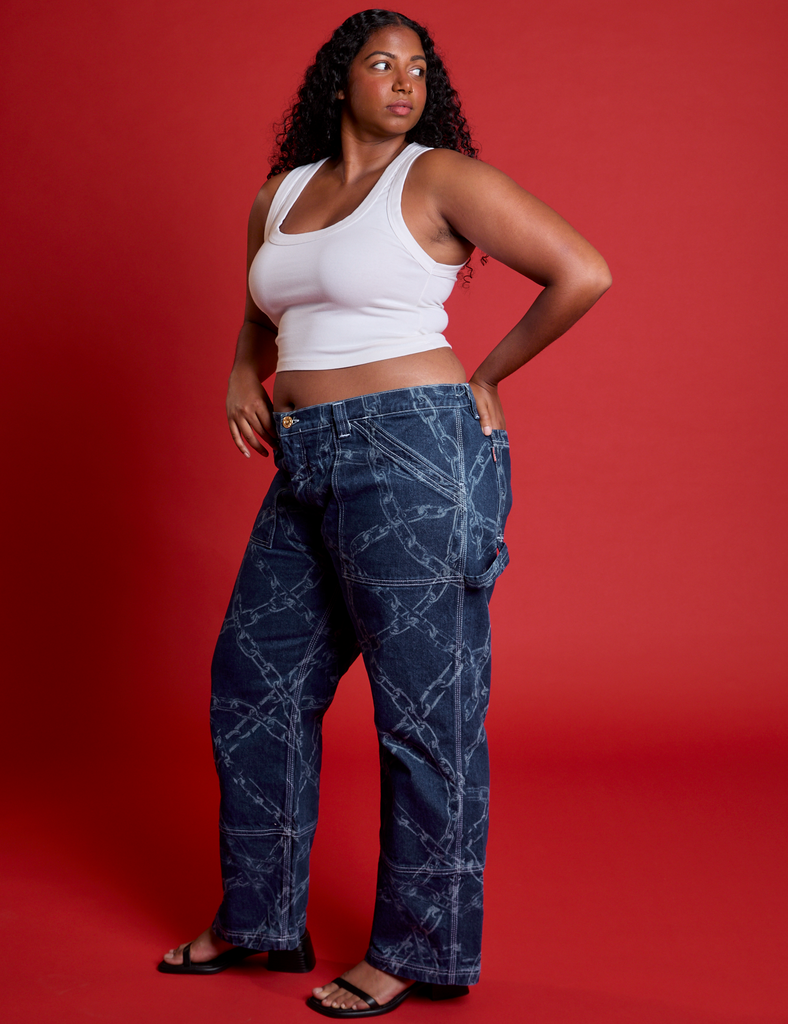 Side view of Mid-Rise Carpenter Jeans in Chain Link and Cropped Tank in Vintage Tee White on Meghna