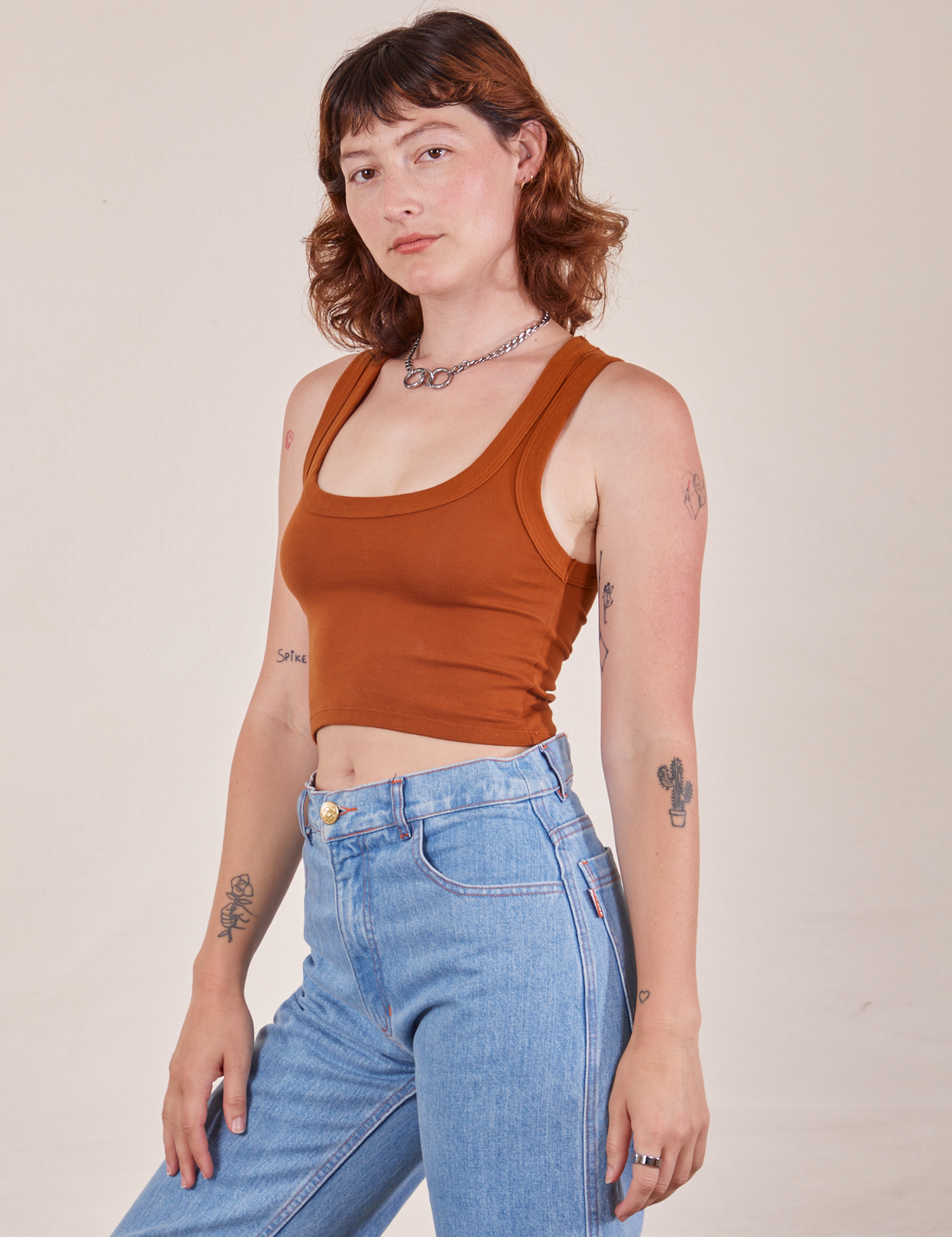 Angled front view of Cropped Tank Top in Burnt Terracotta worn by Alex